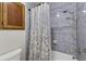 Tiled shower area with modern fixtures and a decorative shower curtain at 11001 Ridgedale Rd, Temple Terrace, FL 33617