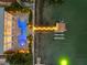 Overhead view of waterfront home showcasing sparkling pool, lit dock, and waterfront access at 11260 7Th E St, Treasure Island, FL 33706