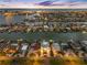 Night aerial shot of waterfront homes with docks and city lights across the bay at 11260 7Th E St, Treasure Island, FL 33706