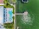 Aerial view of a home with a backyard pool and dock on a waterway, surrounded by green vegetation at 11260 7Th E St, Treasure Island, FL 33706