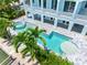 Aerial view of a backyard area with a pool and spa with Palm Trees surrounded by green vegetation at 11260 7Th E St, Treasure Island, FL 33706