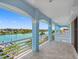Spacious tiled balcony with light-blue trim offers panoramic views of the waterway and clear blue skies at 11260 7Th E St, Treasure Island, FL 33706