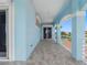 Open-air balcony with blue accents offering views of lush landscaping and distant waterways at 11260 7Th E St, Treasure Island, FL 33706