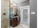 Bathroom with a shower, wood vanity, granite countertop, decorative lighting, and an exit door at 11260 7Th E St, Treasure Island, FL 33706