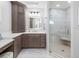 Bathroom with marble shower, glass doors, and cabinetry with double sinks at 11260 7Th E St, Treasure Island, FL 33706