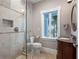 Elegant bathroom with a glass shower, vanity with granite countertop, and a window offering a lovely outdoor view at 11260 7Th E St, Treasure Island, FL 33706