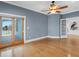 The bedroom features hardwood floors, a ceiling fan, natural light, and sliding glass doors leading to an outdoor balcony at 11260 7Th E St, Treasure Island, FL 33706