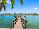 This waterfront home offers a private wooden dock with boat lifts, and picturesque views of the surrounding water and homes at 11260 7Th E St, Treasure Island, FL 33706