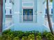 Charming front entrance of a light blue home, featuring a covered porch and manicured garden at 11260 7Th E St, Treasure Island, FL 33706