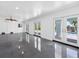 Bright living room with gray floors, white walls, a ceiling fan, and multiple glass doors to the outside at 11260 7Th E St, Treasure Island, FL 33706
