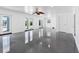 Bright living room with gray floors, white walls, a ceiling fan, and multiple glass doors to the outside at 11260 7Th E St, Treasure Island, FL 33706