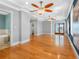 Large main bedroom featuring wood floors, tray ceiling with fans, and a balcony overlooking the water at 11260 7Th E St, Treasure Island, FL 33706