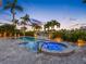 Inviting pool and hot tub surrounded by pavers, lush landscaping, and water views for ultimate relaxation at 11260 7Th E St, Treasure Island, FL 33706