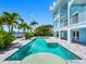 Gorgeous pool and backyard area of a light-blue three-story waterfront home on a sunny day at 11260 7Th E St, Treasure Island, FL 33706