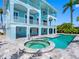 Backyard area showing a pool and spa next to a blue two-story home with multiple balconies at 11260 7Th E St, Treasure Island, FL 33706