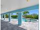 Outdoor patio area showing a spa and a pool with blue trim and blue support pillars at 11260 7Th E St, Treasure Island, FL 33706