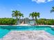 Backyard pool area showing a dock and a backyard area with Palm Trees and lush green bushes at 11260 7Th E St, Treasure Island, FL 33706