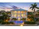 Beautiful back elevation of the home at dusk with a sparkling pool and tropical landscaping at 11260 7Th E St, Treasure Island, FL 33706