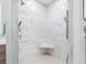 Marble shower with multiple shower heads, a built-in seat, and decorative tile at 11260 7Th E St, Treasure Island, FL 33706