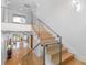 Bright foyer showcasing a staircase with glass railings and hardwood floors with views to a living area at 11260 7Th E St, Treasure Island, FL 33706