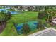 Overhead view of a community basketball court surrounded by manicured lawns, a lake, and mature trees at 11325 78Th E St, Parrish, FL 34219