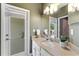 A well-lit bathroom vanity area with granite countertops and a framed mirror, with access to the outdoor patio at 11325 78Th E St, Parrish, FL 34219