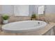 An inviting bathroom featuring a modern standalone bathtub complemented by stylish stone tile at 11325 78Th E St, Parrish, FL 34219