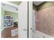 This bathroom entryway provides a glimpse of an adjacent study and the tiled shower area, offering privacy at 11325 78Th E St, Parrish, FL 34219