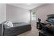 A cozy bedroom with a comfortable bed, desk, and modern gaming computer setup near a sunlit window at 11325 78Th E St, Parrish, FL 34219
