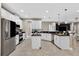 Spacious kitchen with white cabinets, black countertops, stainless steel appliances, and a central island at 11325 78Th E St, Parrish, FL 34219