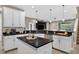 Stylish kitchen featuring white cabinetry, dark countertops, stainless steel appliances, and a central island at 11325 78Th E St, Parrish, FL 34219