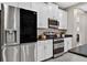Modern kitchen with stainless steel appliances, white cabinets and stunning mosaic backsplash at 11325 78Th E St, Parrish, FL 34219