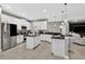 Open kitchen with white cabinets, black countertops, stainless steel appliances, and an island with bar seating at 11325 78Th E St, Parrish, FL 34219