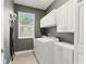 Well-organized laundry room with gray walls, white cabinets, washer, and dryer at 11325 78Th E St, Parrish, FL 34219