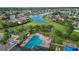 Aerial view of a sparkling community pool surrounded by lush landscaping, homes, and a serene lake at 11325 78Th E St, Parrish, FL 34219