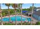 A picturesque pool area with palm trees, umbrellas, and a playground visible in the background at 11325 78Th E St, Parrish, FL 34219