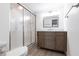 Updated bathroom with a wood vanity, marble countertop, framed mirror, and walk-in shower with glass door at 1150 Tarpon Center Dr # 1D, Venice, FL 34285
