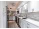 Modern kitchen with white cabinets, stainless steel appliances, and light gray backsplash at 1150 Tarpon Center Dr # 1D, Venice, FL 34285
