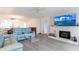 Bright living room with hardwood floors, a fan, fireplace, large TV and kitchen access at 1150 Tarpon Center Dr # 1D, Venice, FL 34285