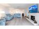 Spacious living room with hardwood floors, fireplace, fan and large TV at 1150 Tarpon Center Dr # 1D, Venice, FL 34285
