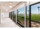Enclosed porch with large windows offering views of lush lawn and palm trees at 1150 Tarpon Center Dr # 1D, Venice, FL 34285