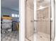Well-lit tiled shower with glass door, grab bars, and seating offers convenience and comfort at 1150 Tarpon Center Dr # 1D, Venice, FL 34285