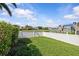 The spacious backyard with white fencing overlooks a tranquil lake, perfect for outdoor enjoyment at 11835 Shrewsbury Ln, Parrish, FL 34219