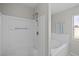 Clean white shower and bathtub with tiled walls, chrome fixtures, and bright natural lighting at 11835 Shrewsbury Ln, Parrish, FL 34219
