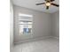 Neutral bedroom with ceiling fan, a window overlooking the yard, and tile flooring at 11835 Shrewsbury Ln, Parrish, FL 34219