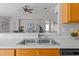Stainless steel double kitchen sink with modern faucet and view to living area at 11835 Shrewsbury Ln, Parrish, FL 34219