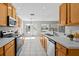 Well-lit kitchen featuring wood cabinetry, white countertops, and stainless steel appliances at 11835 Shrewsbury Ln, Parrish, FL 34219