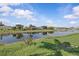 Picturesque view of a calm lake reflecting the sky, surrounded by lush greenery at 11835 Shrewsbury Ln, Parrish, FL 34219