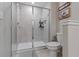 Modern bathroom with a glass-enclosed shower, toilet, and decorative wall art at 11916 Castine St, New Port Richey, FL 34654