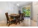 Cozy dining room with a wooden table, upholstered chairs, and sliding glass doors to the lanai at 11916 Castine St, New Port Richey, FL 34654